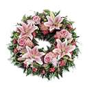 Pink Loose Wreath in Seasonal Pink - comprising of seasonal pink lilies and roses mixed with other seasonal pink flowers.